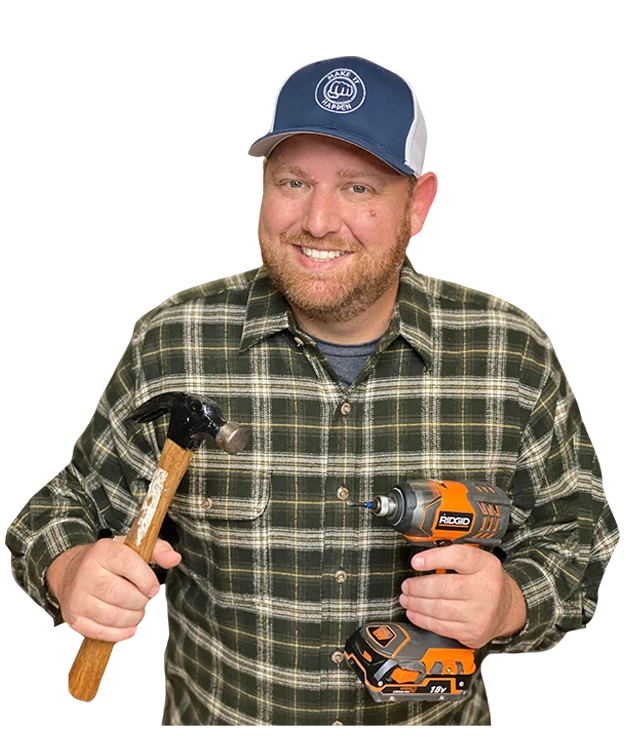Ryan Gromfin holding a hammer and a drill